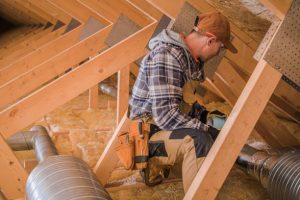 Professional Ventilation and Air Cleaning System. Installer Checking Filtering Elements. Attic Pipeline.